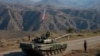 Servicemen from Russian peacekeeping troops stand next to a tank near the Armenian border following the signature of a November 9, 2020 deal to end the military conflict between Azerbaijan and ethnic Armenian forces in the breakaway region of Nagorno-Karabakh. 